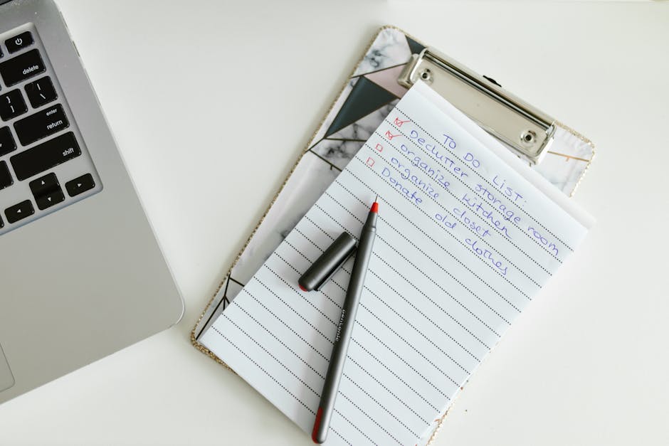A neatly organized to-do list on a clipboard next to a laptop and pen, conveying productivity.