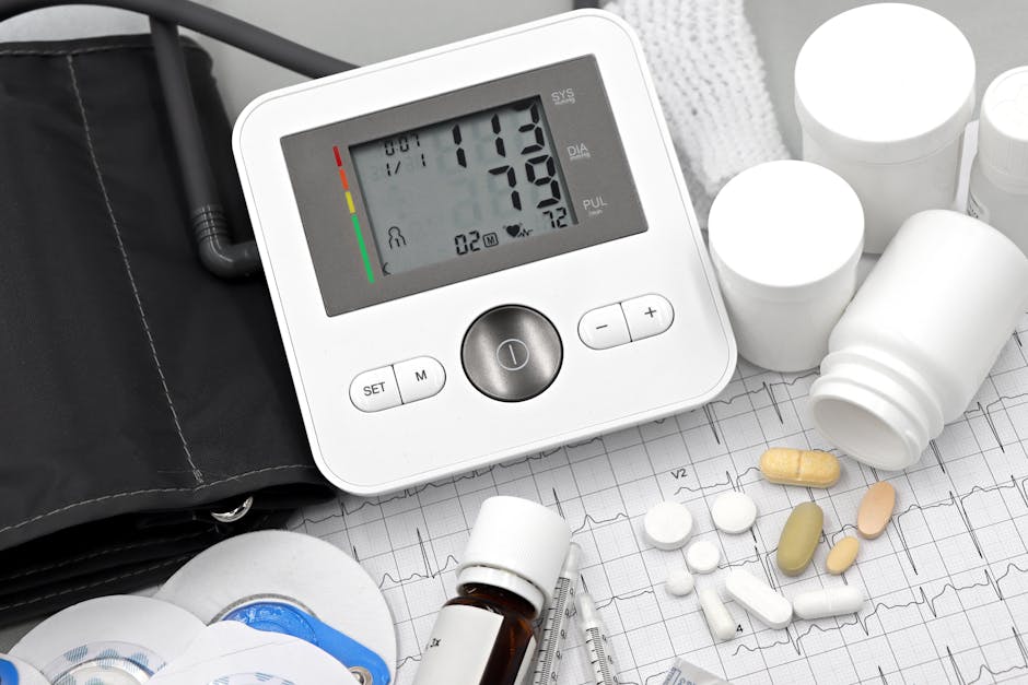 Digital blood pressure monitor on ECG paper with pills and medical supplies, ideal for healthcare topics.