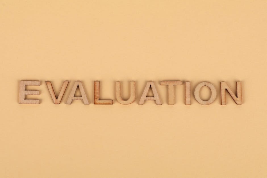 Wooden letter blocks arranged to spell 'evaluation' on a beige background.