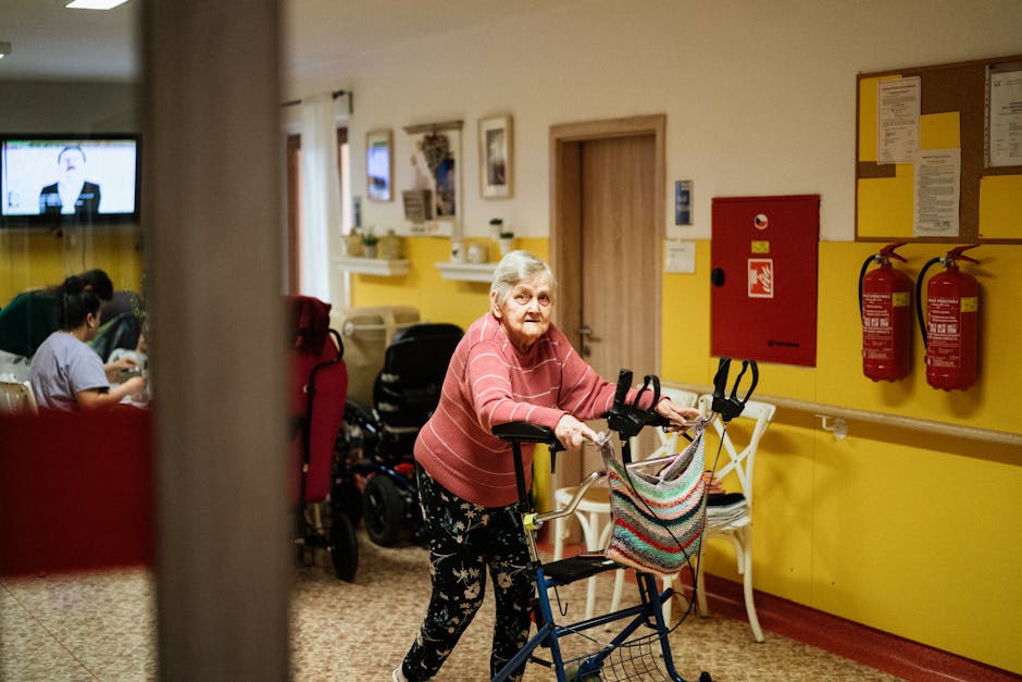Senior woman using a walking frame in a cozy nursing home interior in Karvin��, Czech Republic.