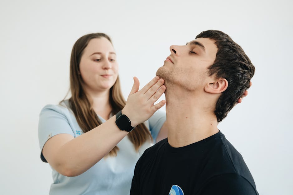 A physiotherapist performs therapy on a male patient's neck in Vilnius clinic.